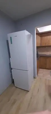 an empty kitchen with a white refrigerator in a room at Apartman Vanja in Paraćin