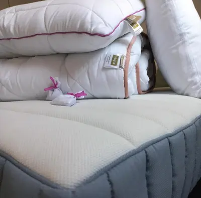 a close up of a bed with pillows and a watch at Tilia Home in Vrnjačka Banja