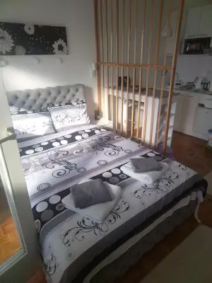 a bed with white sheets and pillows in a room at AIK Kula studio in Jagodina