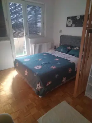 a bedroom with a bed with a blue comforter at AIK Kula studio in Jagodina