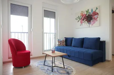 a living room with a blue couch and a red chair at Apartman Ruby in Vrnjačka Banja