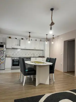 a kitchen with a table and chairs in a room at IKONIJA guest house in Pečenjevce