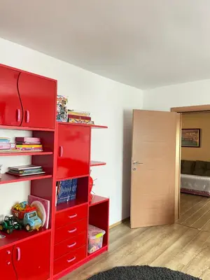 a red cabinet in a room with a bedroom at IKONIJA guest house in Pečenjevce