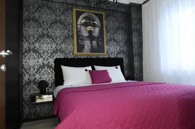 a bedroom with a pink bed with a black wall at Aljoša Luxury Apartment in Jagodina
