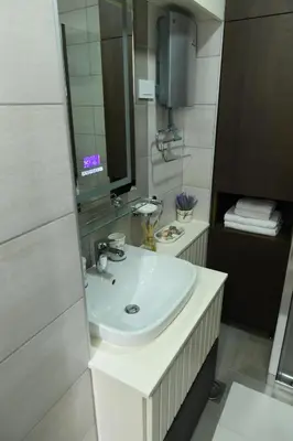 a bathroom with a white sink and a mirror at Aljoša Luxury Apartment in Jagodina