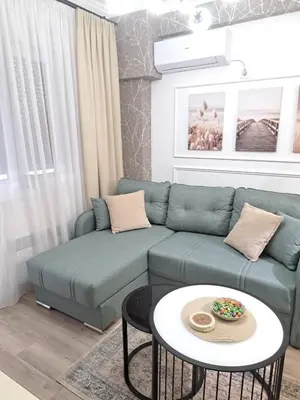 a living room with a blue couch and a table at Aljoša Luxury Apartment in Jagodina