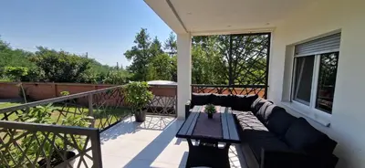 a patio with a couch and a table on a balcony at Vila Elena in Niš