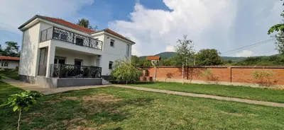 a white house with a fence and a yard at Vila Elena in Niš
