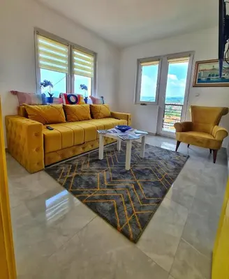 a living room with a yellow couch and a table at Apartman Berlin Sokobanja in Soko Banja
