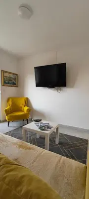 a living room with a couch and a tv on a wall at Apartman Berlin Sokobanja in Soko Banja