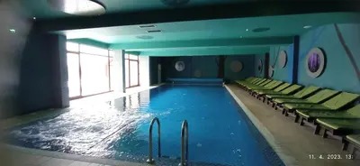 a large swimming pool with chairs in a building at Planinska idila in Kopaonik
