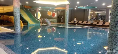 a pool in a hotel with a water slide at Planinska idila in Kopaonik