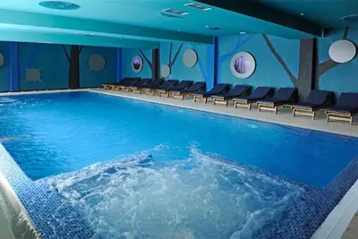 a large swimming pool with chairs in a building at Planinska idila in Kopaonik