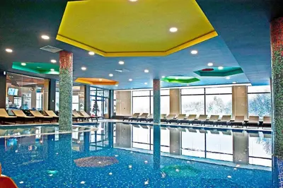 a large swimming pool with chairs in a building at Planinska idila in Kopaonik