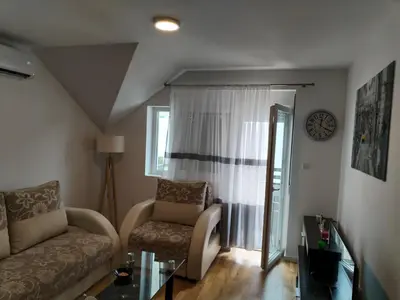 a living room with a couch and a chair at HUGO APARTMAN Green Hill Kompleks- u blizini Akva Parka in Soko Banja