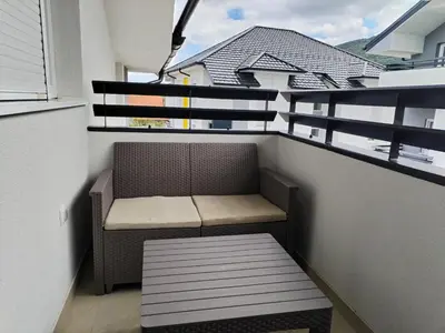 a small balcony with a bench and a window at HUGO APARTMAN Green Hill Kompleks- u blizini Akva Parka in Soko Banja