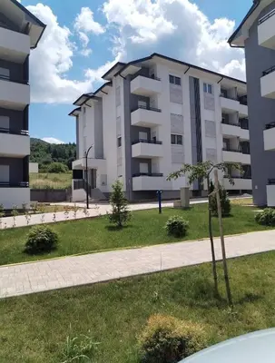 a large apartment building with a grass yard at HUGO APARTMAN Green Hill Kompleks- u blizini Akva Parka in Soko Banja