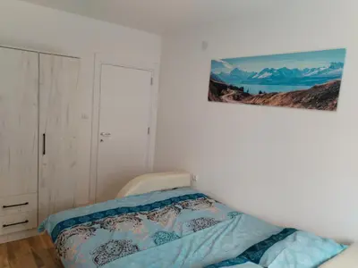 a bedroom with a bed and a picture on the wall at HUGO APARTMAN Green Hill Kompleks- u blizini Akva Parka in Soko Banja