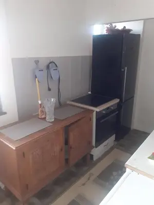 a kitchen with a black refrigerator and a wooden table at NIKOLIĆ APARTMAN in Vranje