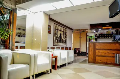 a dining room with white chairs and a bar at Bell Inn in Leskovac