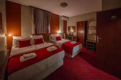 a hotel room with two beds and a bathroom at Bell Inn in Leskovac