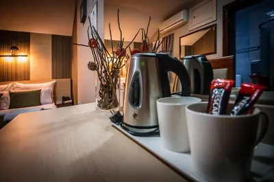 a kitchen counter with a coffee maker and cups on it at Bell Inn in Leskovac