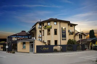 a building with a sign on the side of it at Bell Inn in Leskovac