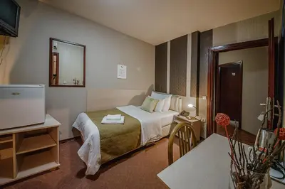 a hotel room with a bed and a television at Bell Inn in Leskovac