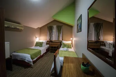 a hotel room with two beds and a mirror at Bell Inn in Leskovac