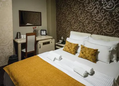 a hotel room with a large bed with towels on it at Bell Inn in Leskovac