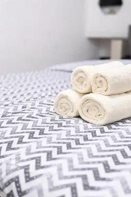 a pile of rolled towels sitting on a bed at Nilton Apartmans in Niš