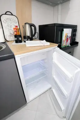 an empty refrigerator with its door open in a kitchen at Nilton Apartmans in Niš