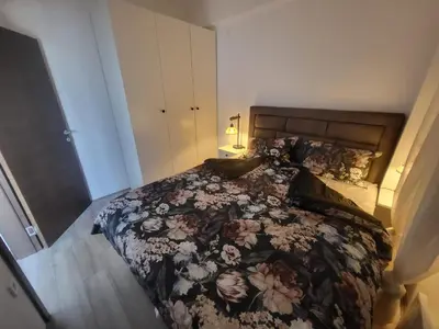 a bedroom with a large bed with a floral blanket at Azur in Jagodina