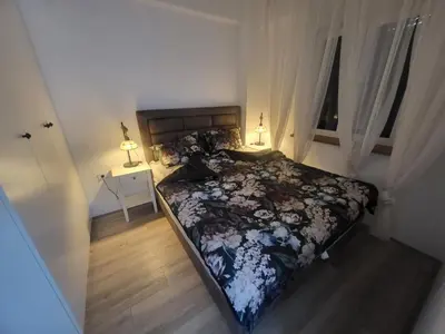 a bedroom with a bed and a window and two lamps at Azur in Jagodina