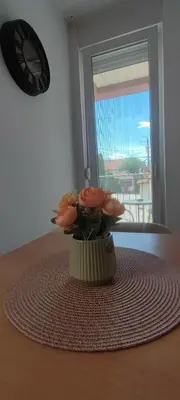 a vase with pink flowers sitting on a table at Soko City Center & Parking Free in Soko Banja