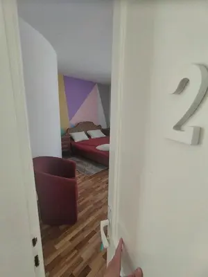 a door to a room with a bedroom with a bed at Villa Ema rooms in Niš