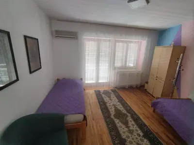 a living room with a purple bed and a window at Villa Ema rooms in Niš
