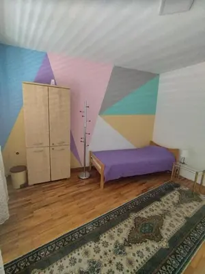 a room with a bed and a colorful wall at Villa Ema rooms in Niš