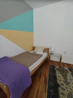 a bedroom with a bed and a colorful wall at Villa Ema rooms in Niš