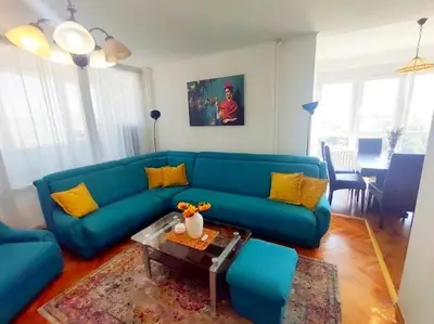 a living room with a blue couch and a table at Apartman Centar in Pirot