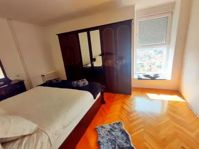 a small bedroom with a bed and a window at Apartman Centar in Pirot
