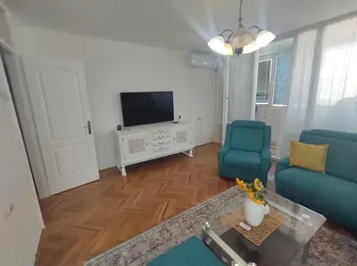 a living room with a blue couch and a tv at Apartman Centar in Pirot