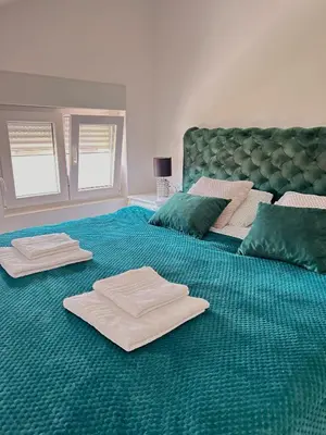a bedroom with two beds with towels on the floor at Apartman Viny in Soko Banja