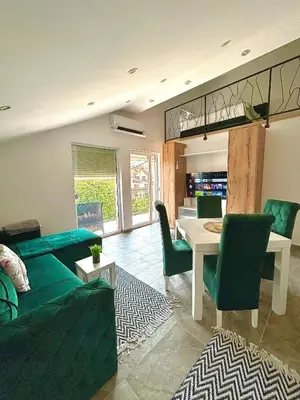 a living room with a green couch and a table at Apartman Viny in Soko Banja