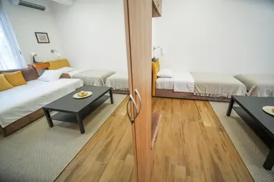 a living room with two beds and a table at PRENOCISTE SOLE in Vranje