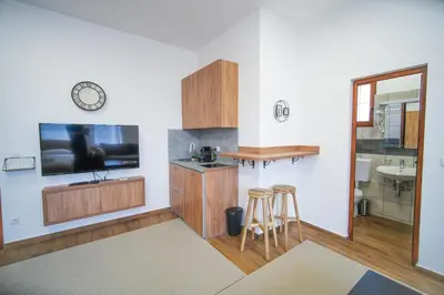 a kitchen with a tv and a counter with stools at PRENOCISTE SOLE in Vranje