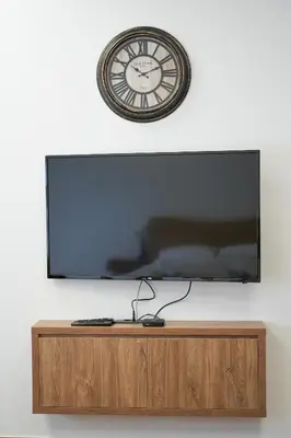 a clock on top of a tv on a wall at PRENOCISTE SOLE in Vranje