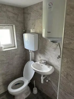 a small bathroom with a toilet and a sink at Rooms Enna in Dimitrovgrad