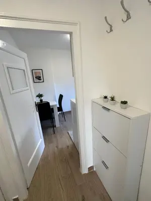 a white room with a white dresser and a table at Boho Apartment in Niš