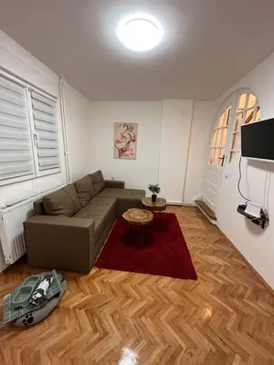 a living room with a couch and a table at Boho Apartment in Niš